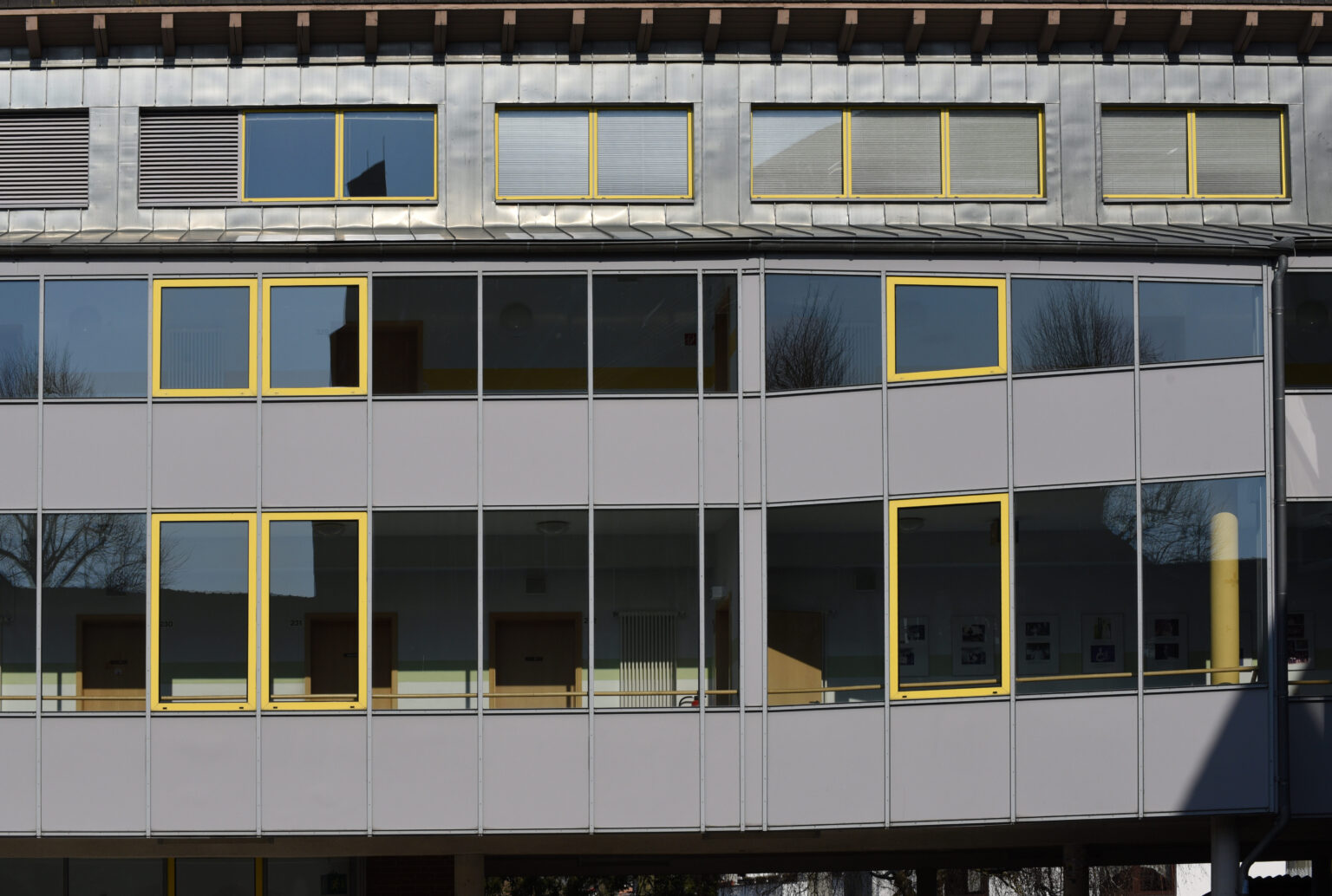 Moderner Anbau mit gelb gerahmter Fensterfront